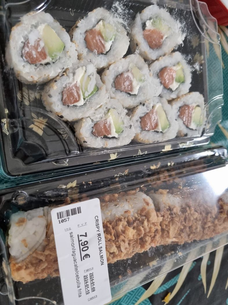 Rolls de salmón y aguacate con sésamo, acompañados de salsa de soja.